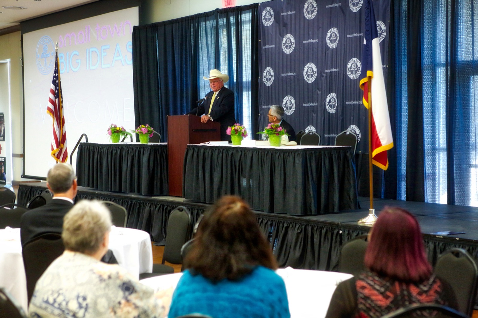 Conference stage with podium speaker and screens